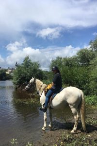 Valérie Winzen à cheval au bord d'une rivière